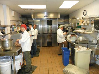 photo of a kitchen with people cooking